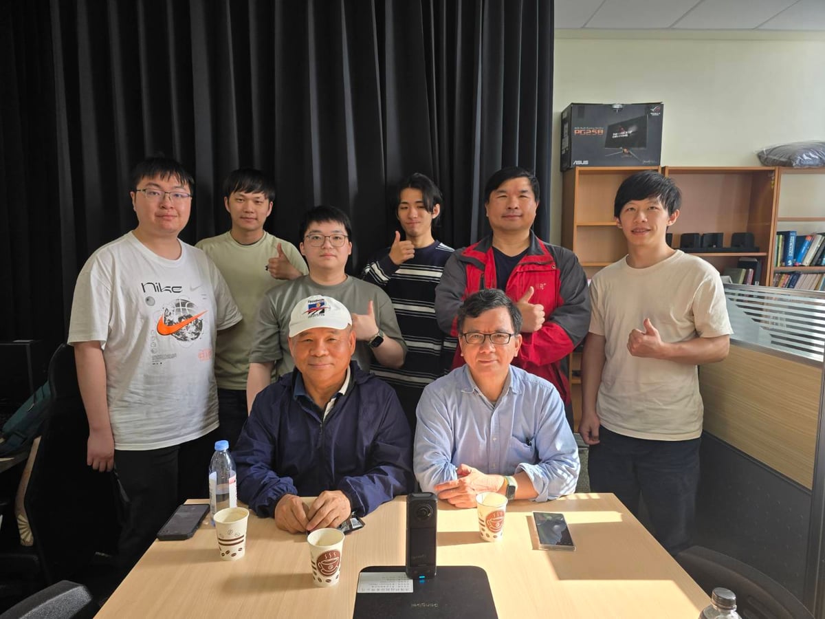 The CMS AI team gathered around a table for a group photo.